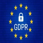 Scritta bianca gdpr con un lucchetto al centro di dodici stelle gialle in cerchio su sfondo blu.